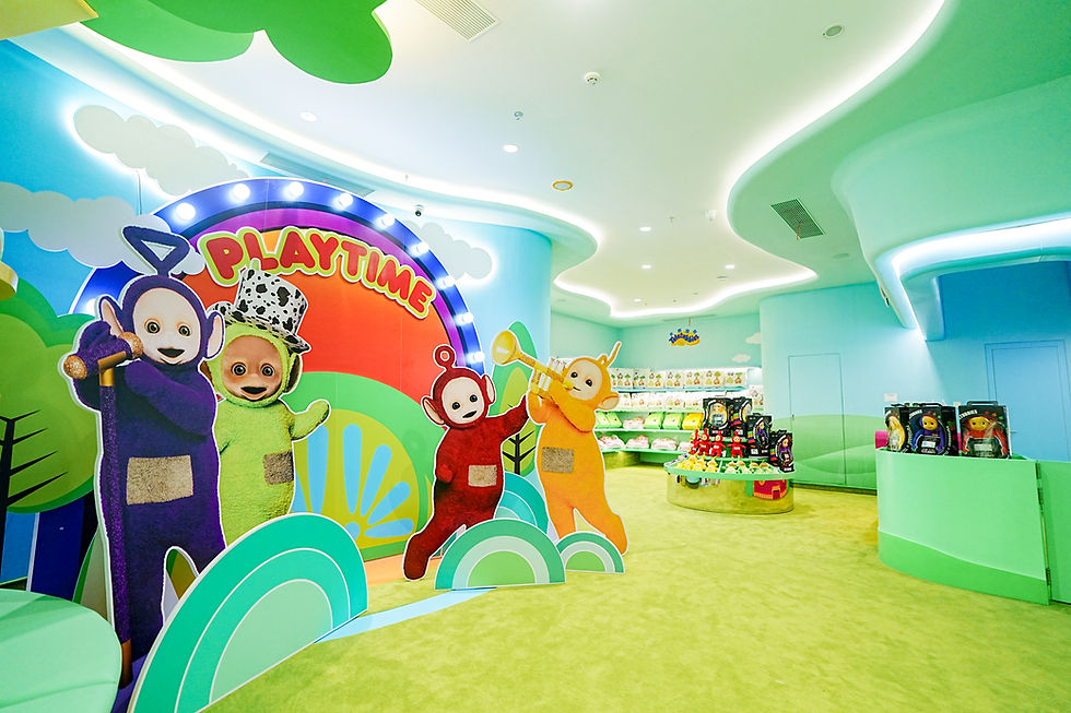 Colorful Teletubbies playroom with PLAYTIME sign, cartoon cutouts, toy displays, and bright blue-green walls and ceiling.