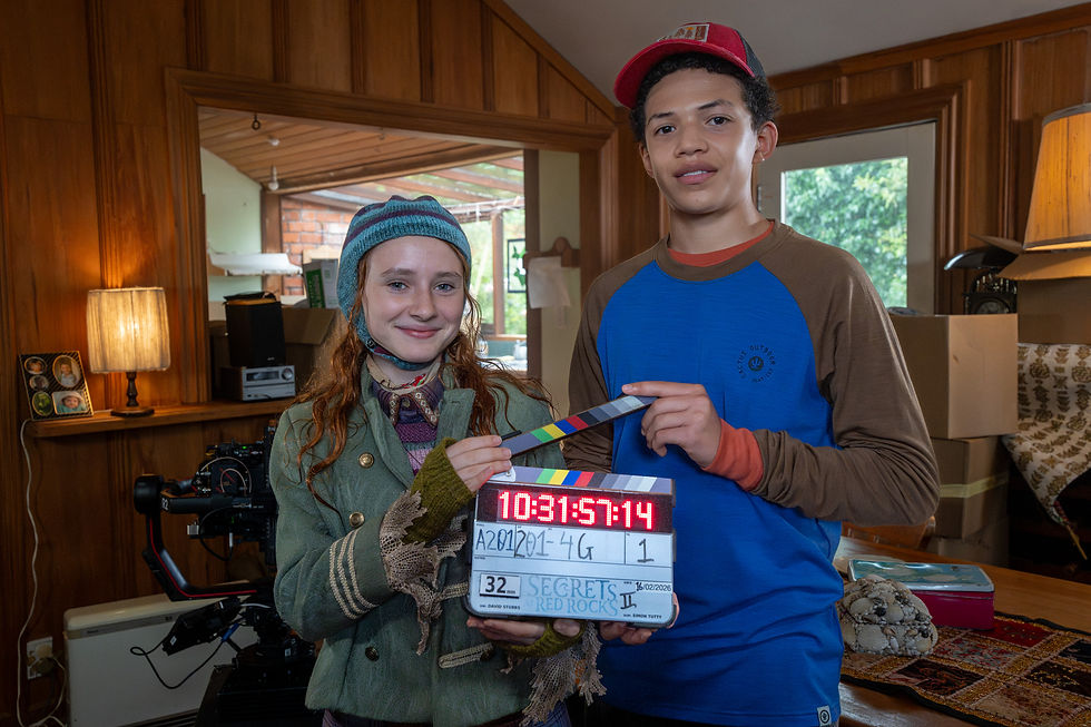 A boy and girl pose with a clapperboard for Secrets at Red Rocks season two.