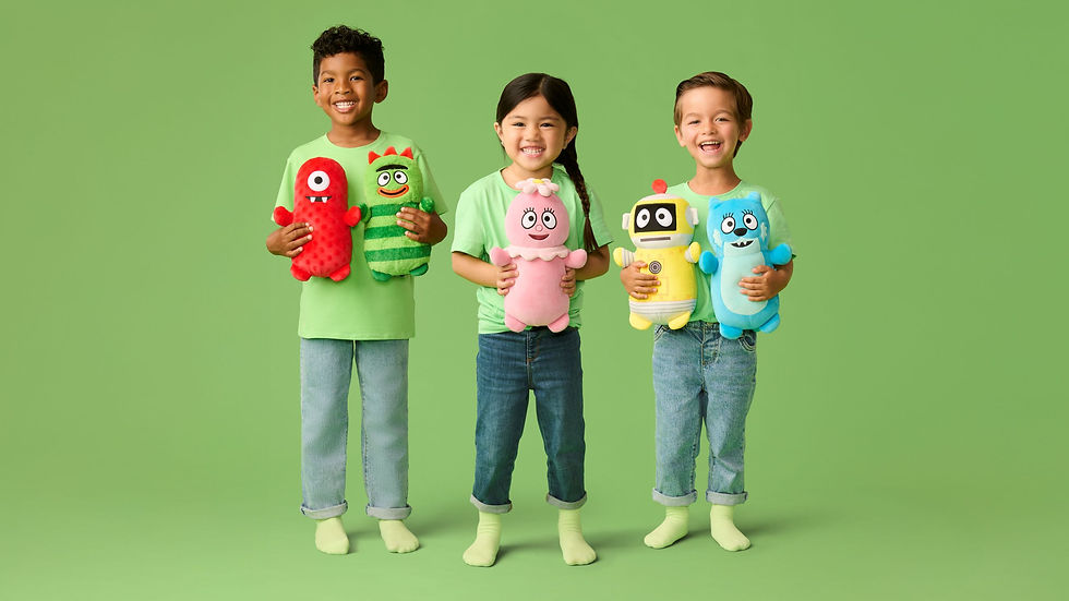 Three children smiling, holding colorful plush toys against a green background.