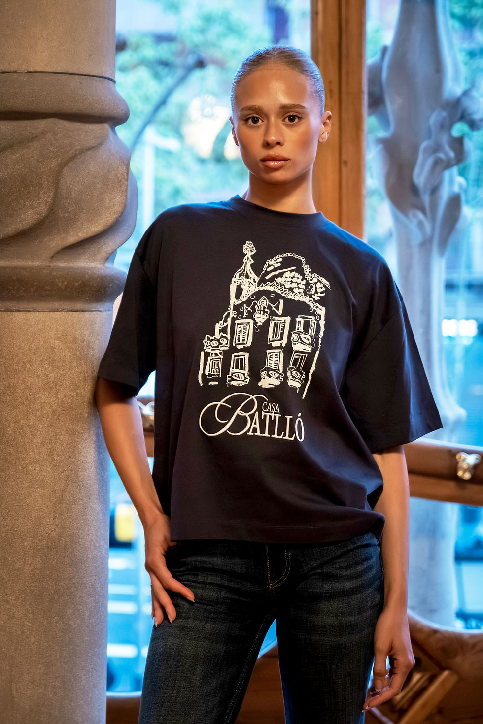 A model wearing a black t-shirt with the Casa Batllo logo on it