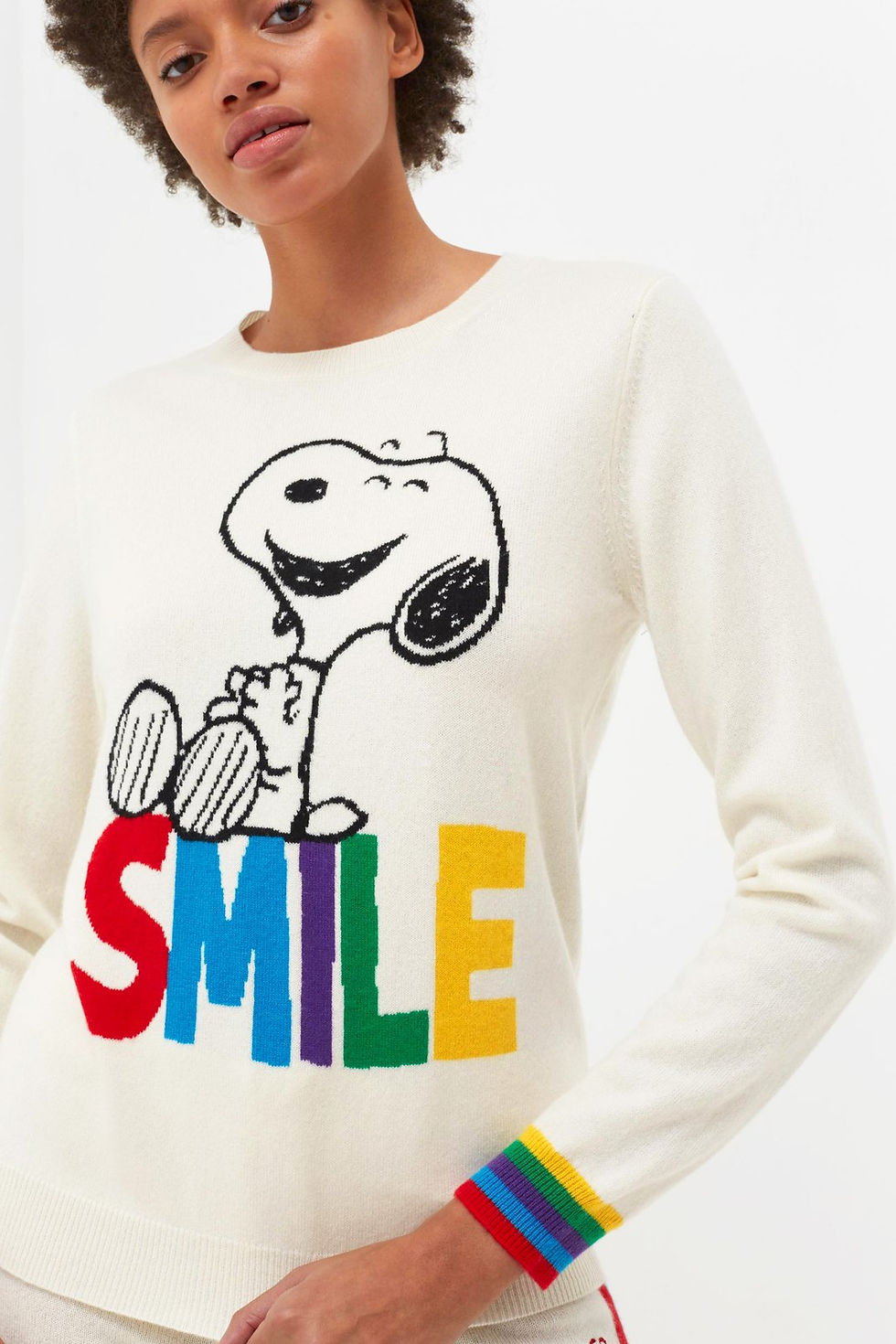 a woman model wearing white sweater with beagle image and word 'smile'