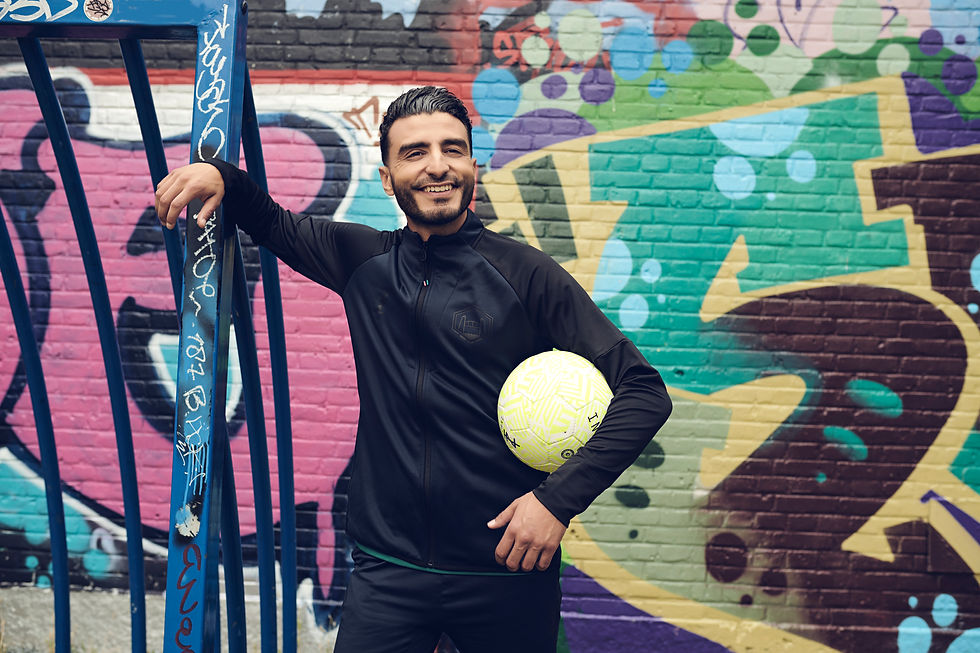 a smiling man holding a yellow football
