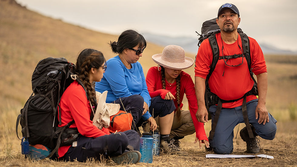 A family in the desert looks at a map trying to decide