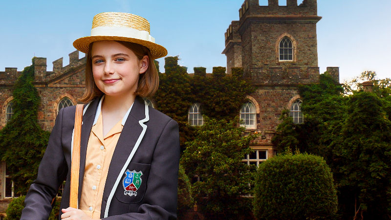 a girl in a straw hat in front of a castle like building