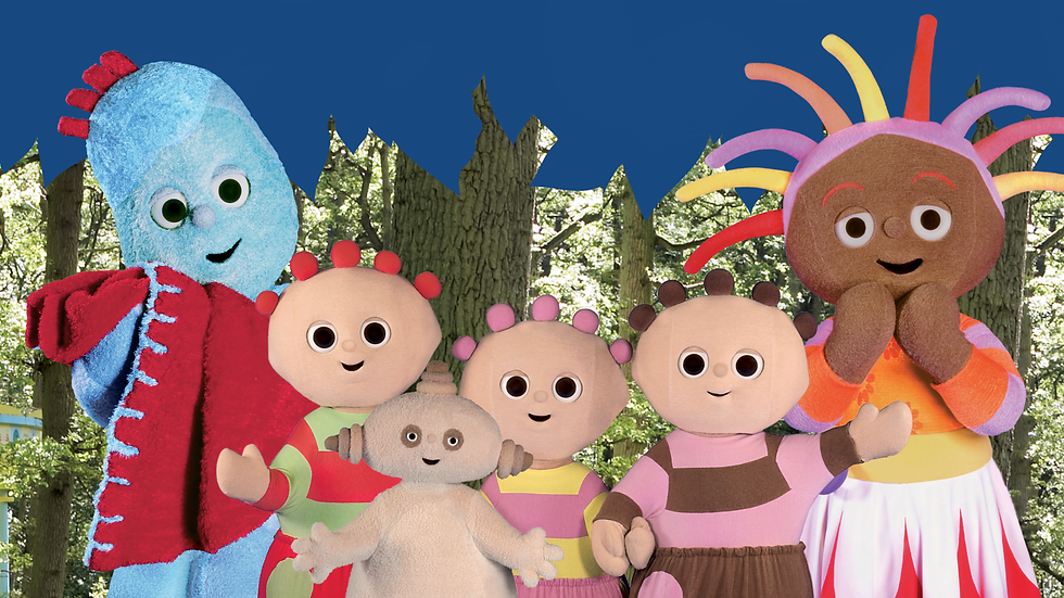 Six costumed characters smile and stare at the camera on a forest backdrop.