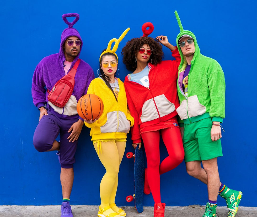 A group of four people lean on a blue wall wearing colourful alien-inspired sports apparel, complete with antennas.