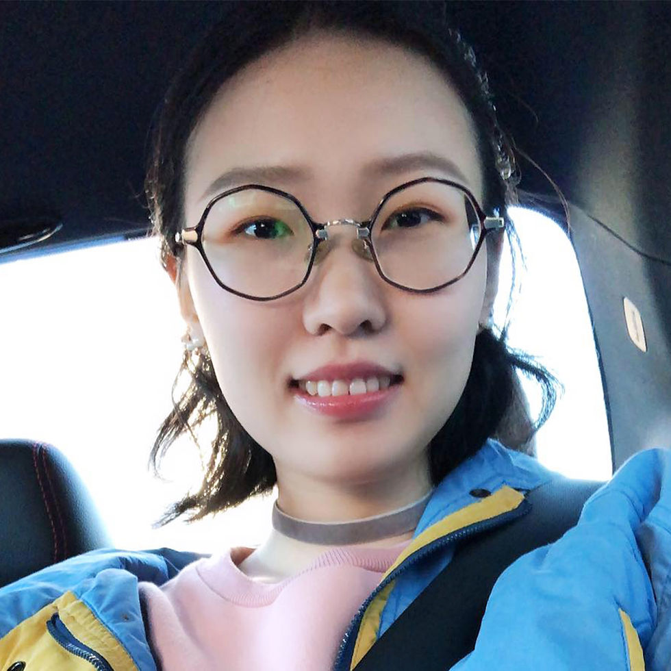 close up of a black haired woman in glasses sitting her car posing for a photo