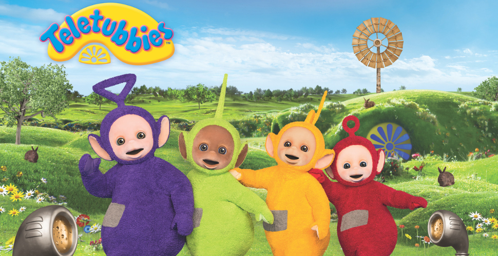 Teletubbies standing in a line with green rolling hills behind. 