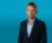 A professional headshot of a man wearing a dark blazer and light blue shirt, photographed against a bright blue background.