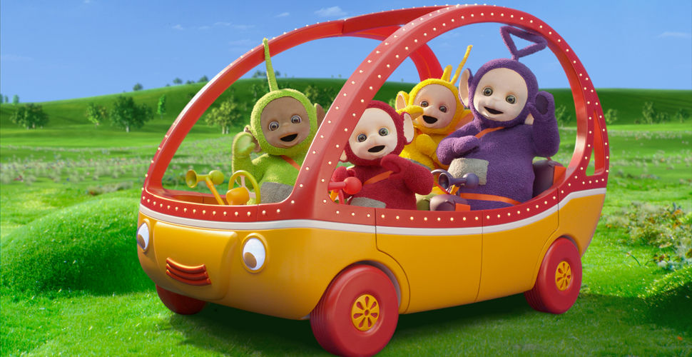 4 fuzzy creatures in a red and orange vehicle in a meadow