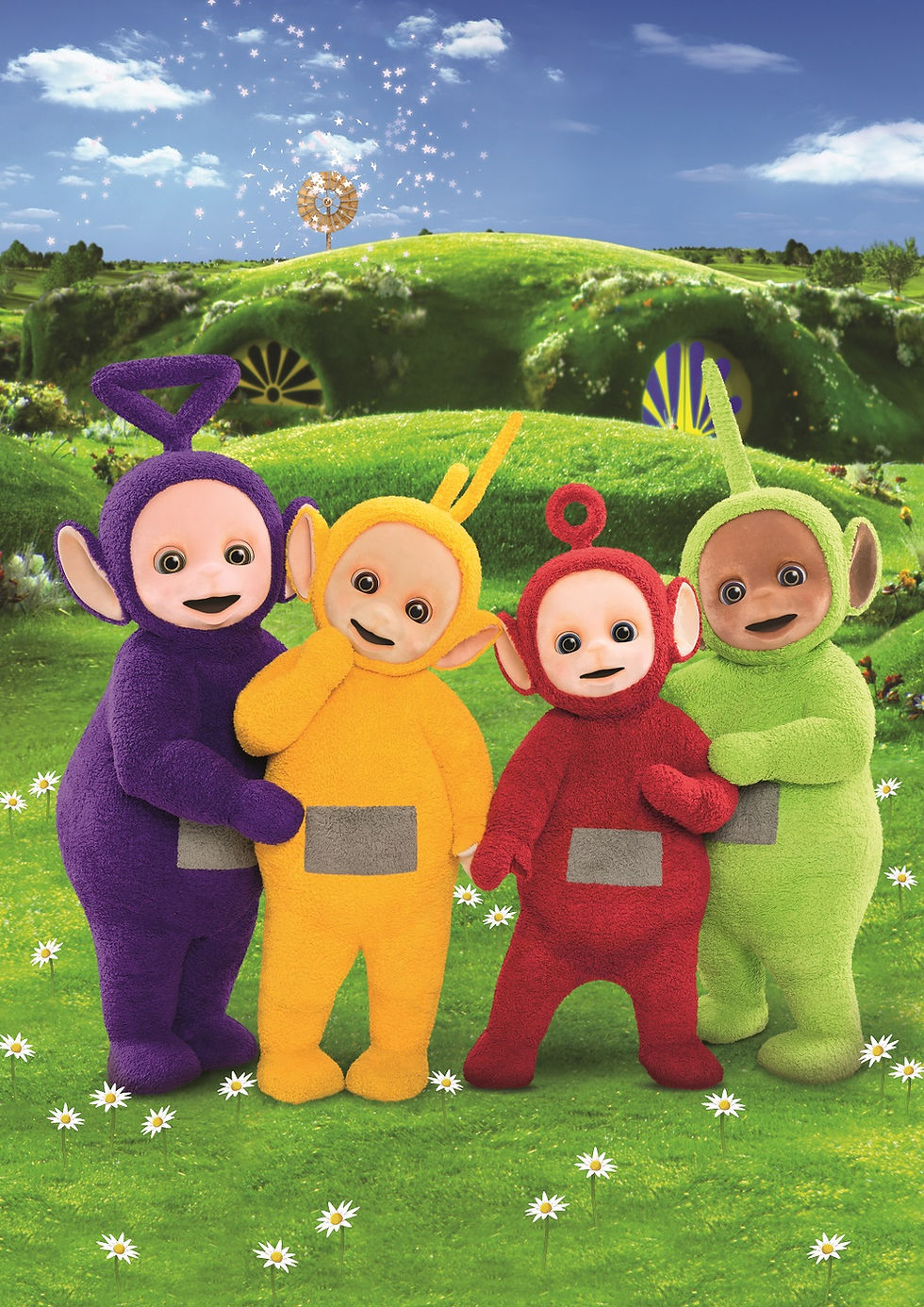 four fuzzy characters standing in on a green hillside