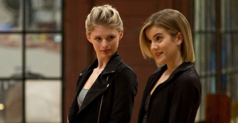 one young woman looks questioningly at another in a dance studio