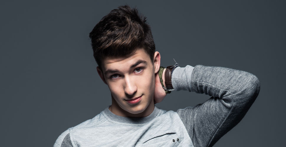 a young man poses with his arm behind his head