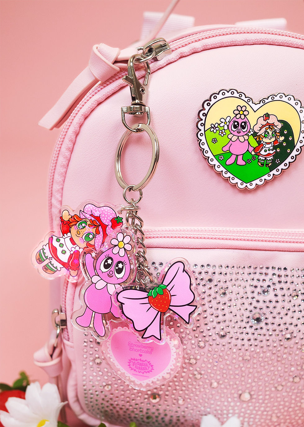 pink backpack with keychains hanging off the zipper pull