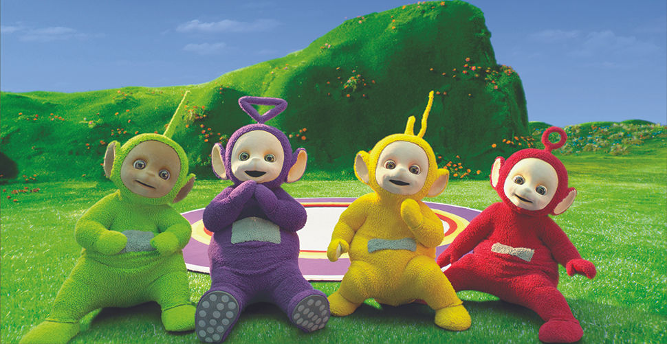 4 fuzzy characters sitting in a meadow in front of a hill