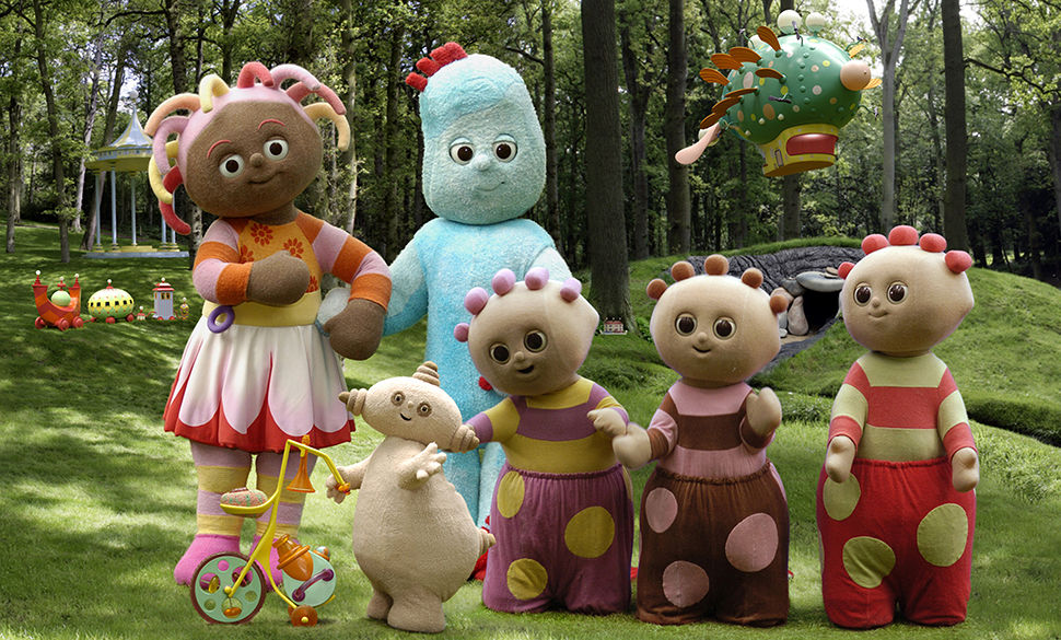 a group of fuzzy colourful characters in a forest