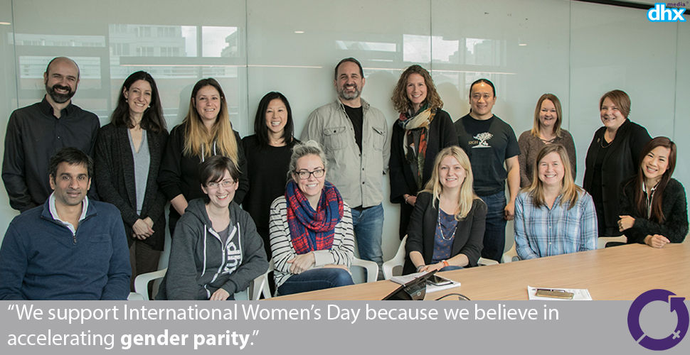 group of employees around a boardroom table. "We support International Women's Day because we believe in accelerating gender parity."